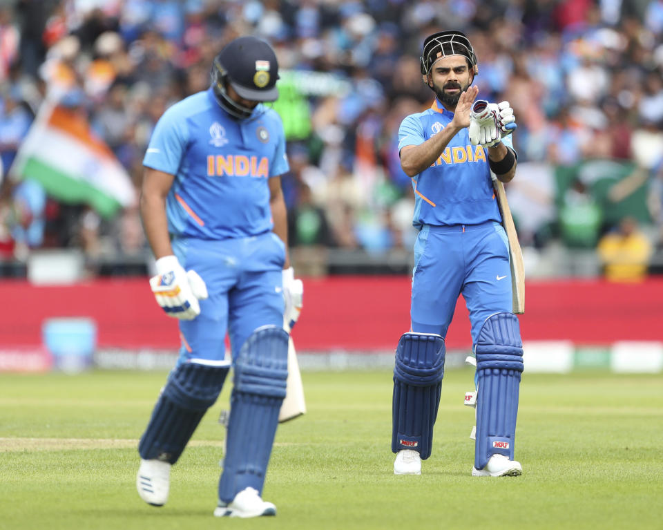 India's captain Virat Kohli, right, applauds teammate Rohit Sharma, left, as he leaves the field after losing his wicket during the Cricket World Cup match between India and Pakistan at Old Trafford in Manchester, England, Sunday, June 16, 2019. (AP Photo/Aijaz Rahi)