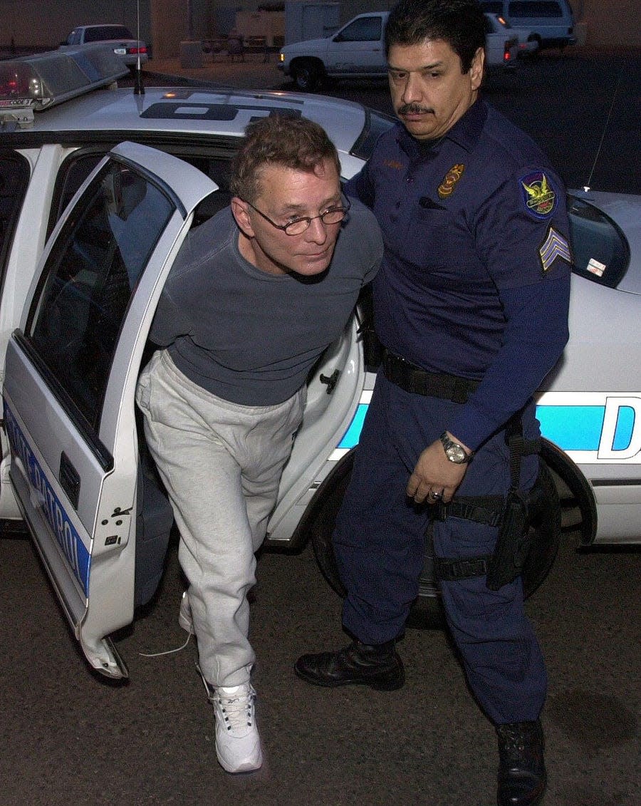 Mafia hit man and turncoat Salvatore "Sammy the Bull" Gravano is escorted to jail by a Phoenix police officer on Thursday, Feb. 24, 2000, after raids on a criminal syndicate dealing in the designer drug Ecstasy. Gravano was booked into Maricopa County Jail on suspicion of drug trafficking.