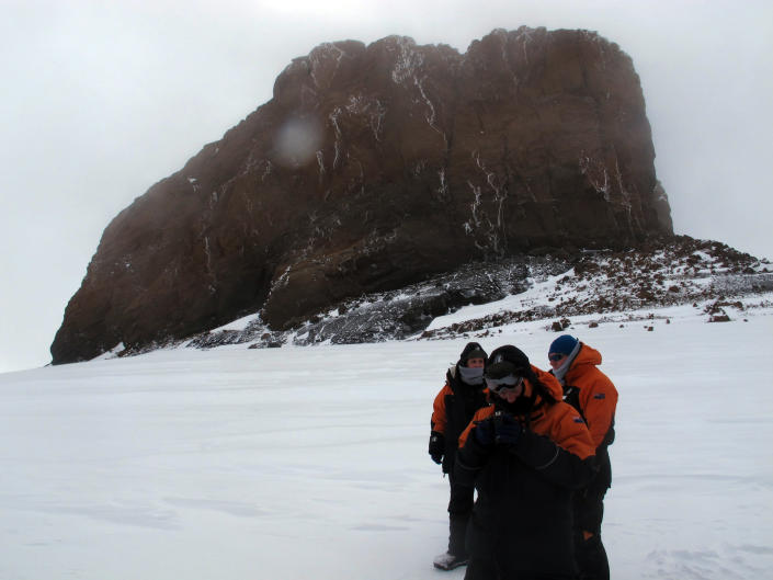 This Jan. 20, 2013 photo shows tourists near Castle Rock on Crater Hill on Ross Island, Antarctica. Tourism is rebounding here five years after the financial crisis stifled what had been a burgeoning industry. And it’s not just retirees watching penguins from the deck of a ship. Visitors are taking tours inland and even engaging in “adventure tourism” like skydiving and scuba diving under the ever-sunlit skies of a Southern Hemisphere summer. (AP Photo/Rod McGuirk)