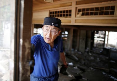 A local resident tries to clear mud and debris from his home at a flood affected area in Mabi town in Kurashiki, Okayama Prefecture, July 13, 2018. REUTERS/Issei Kato