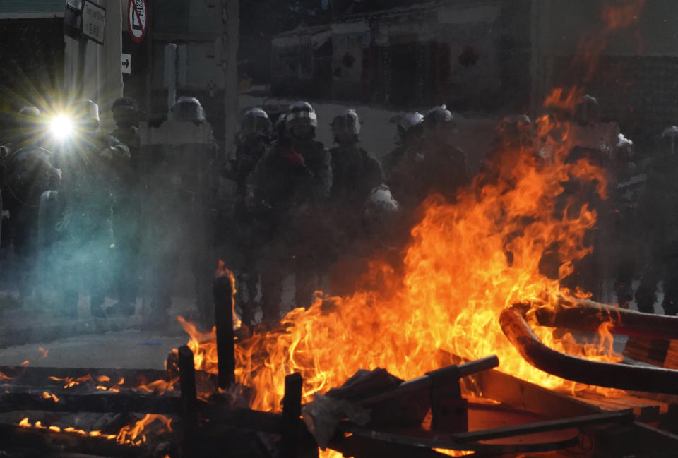 Police face a burning barricade during protests in Hong Kong on Saturday, Sept. 21, 2019. Protesters in Hong Kong burned a Chinese flag and police fired pepper spray Saturday in renewed clashes over grievances by the anti-government demonstrators. (AP Photo/Vincent Yu)