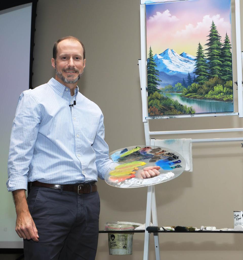 Nicholas Hankins poses in front of a painting he just finished during The Joy Continues event at the Brannon Center, Thursday, April 4, 2024.