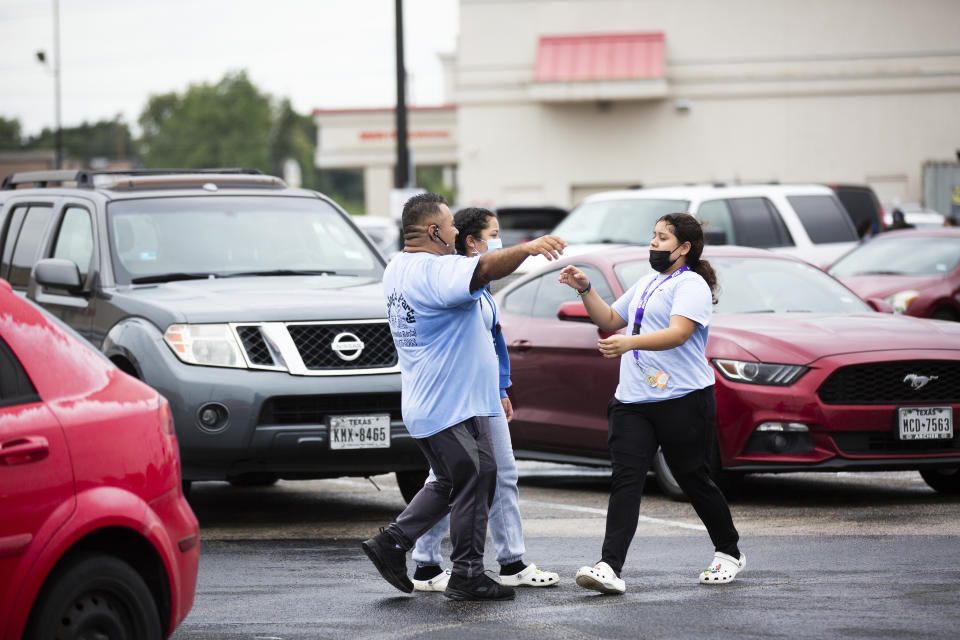 Yes Prep Southwest Secondary school 8th grader Kimberly Mendez, 14, rushes to embrace her father Rudis and sister Ashley, 16, 11th grade, at a parking lot on the corner of Hiram Clarke Rd. and W. Fuqua St. after an alleged shooting took place at her school, YES Prep Southwest Secondary school, on Friday, Oct. 1, 2021, in Houston. An employee at the Houston charter school was shot and wounded by a former student, police said. Houston Police Chief Troy Finner said a 25-year-old man surrendered after being surrounded by police. (Marie D. De Jesús/Houston Chronicle via AP)