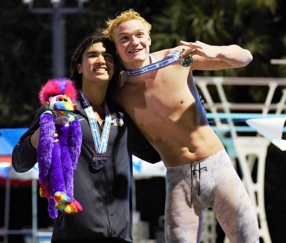 Gainesville's Michael Mullen (right) and Nease's Rich Ngyuen celebrate their 1-2 finish in the 100 breaststroke at the 2022 Florida High School Athletic Association Class 3A Swimming and Diving State Championships on Friday, Nov. 4, 2022, at Sailfish Splash Waterpark in Stuart. Mullen won the race with a time of 55.61.