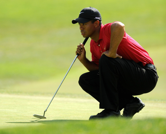 Tiger Woods lines up a putt on the first hole.