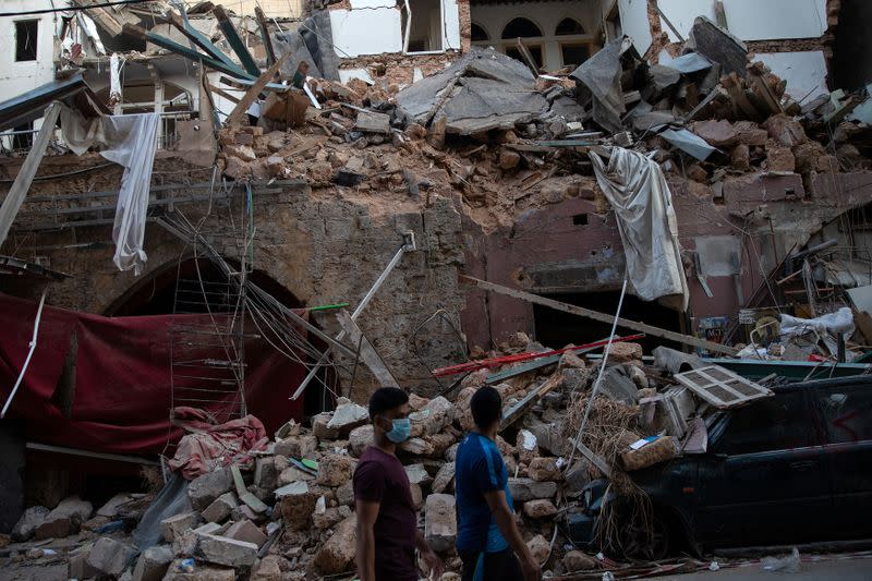 Gente camina frente a casas libanesas tradicionales destruidas luego de una enorme explosión en el área del puerto de Beirut