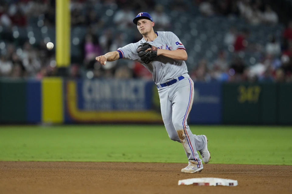 Texas Rangers shortstop Corey Seager (5) throws to first to out Los Angeles Angels' Brandon Drury during the third inning of a baseball game in Anaheim, Calif., Tuesday, Sept. 26, 2023. (AP Photo/Ashley Landis)