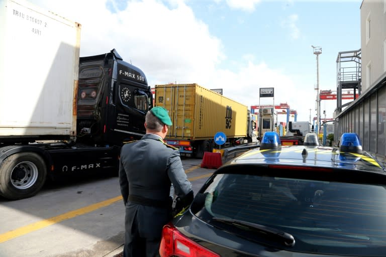 Un officier de la Guardia di Finanza, la police italienne chargée de la criminalité financière et de la contrebande, observent des camions dans la zone commerciale du port de Naples, le 29 février 2024 (CARLO HERMANN)