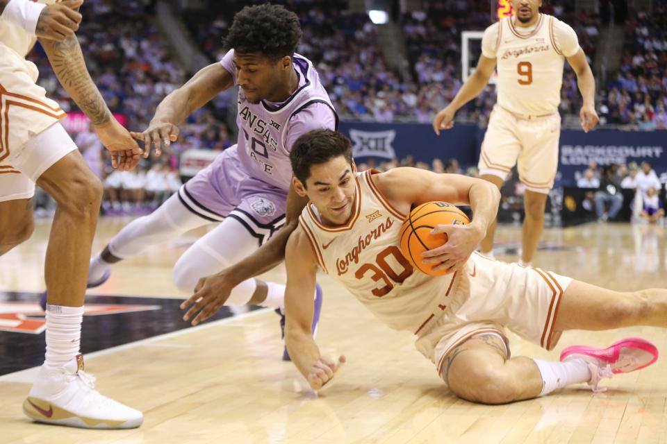 Texas graduate senior forward Brock Cunningham, right, recovers a loose ball against Kansas State in the first half of the Big 12 Conference Tournament second-round game Wednesday at the T-Mobile Center in Kansas City, Mo.