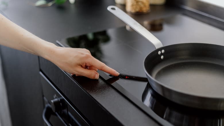 person pointing at stove temperature