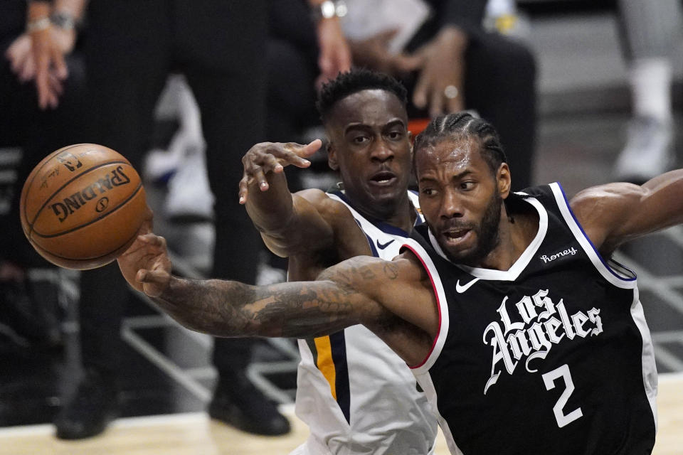 Los Angeles Clippers forward Kawhi Leonard, right, passes the ball while under pressure from Utah Jazz guard Miye Oni during the second half of Game 3 of a second-round NBA basketball playoff series Saturday, June 12, 2021, in Los Angeles. (AP Photo/Mark J. Terrill)