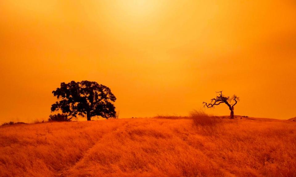 An orange sky filled with wildfire smoke hangs above hiking trails at the Limeridge Open Space in Concord, California.