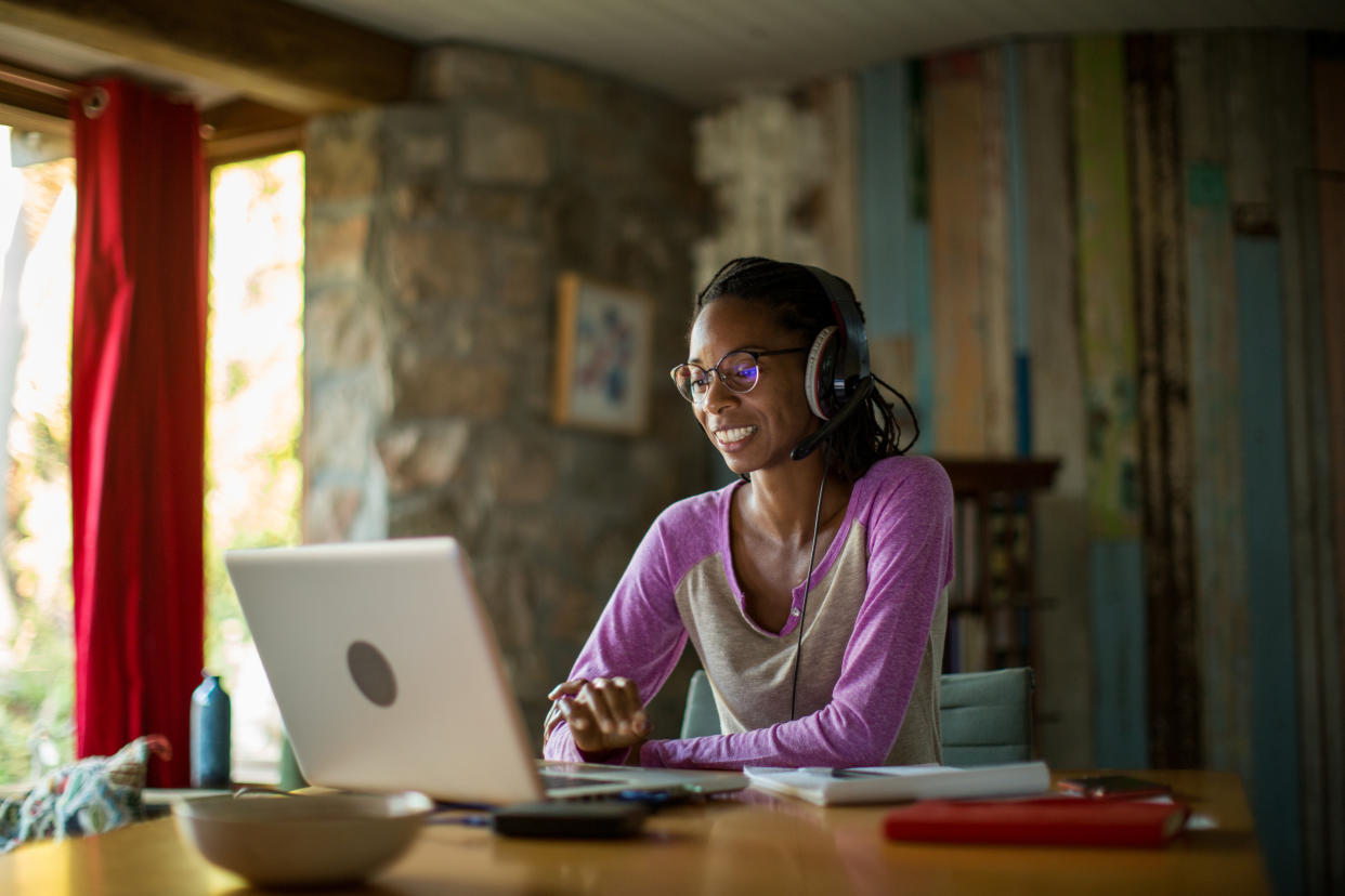 Woman working remotely with laptop computer on table