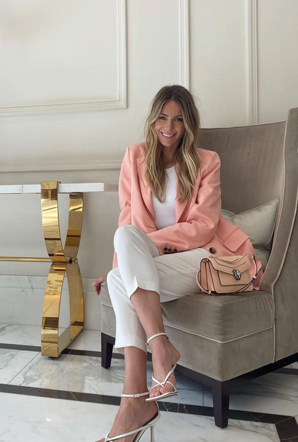 Jennifer Hawkins in a pink jacket and white trousers