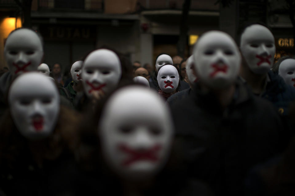 FILE - In this Thursday, April. 5, 2018 file photo people wear white masks in support of Catalonian politicians jailed on charges of sedition and condemning the arrest of Catalonia's former president, Carles Puigdemont, in Germany, during a protest in Figures, Spain. (AP Photo/Emilio Morenatti, File)