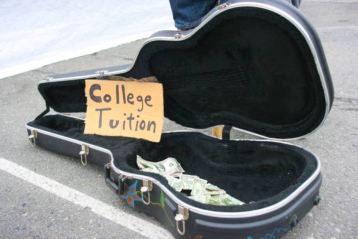 An empty guitar case with money in it and a sign saying "College tuition"