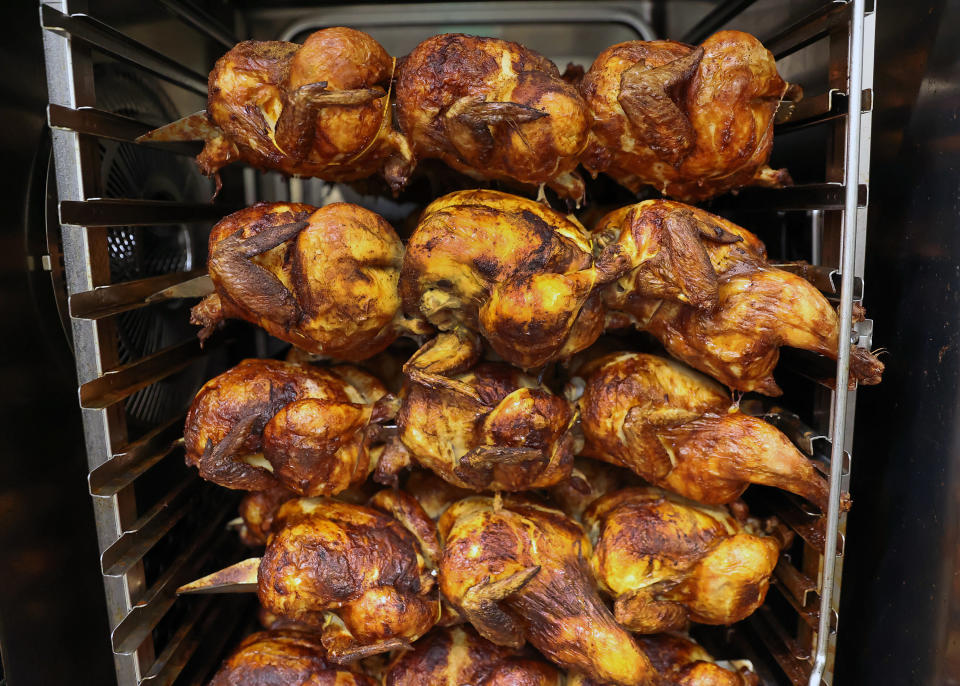Rotisserie chickens cooking at a grocery store