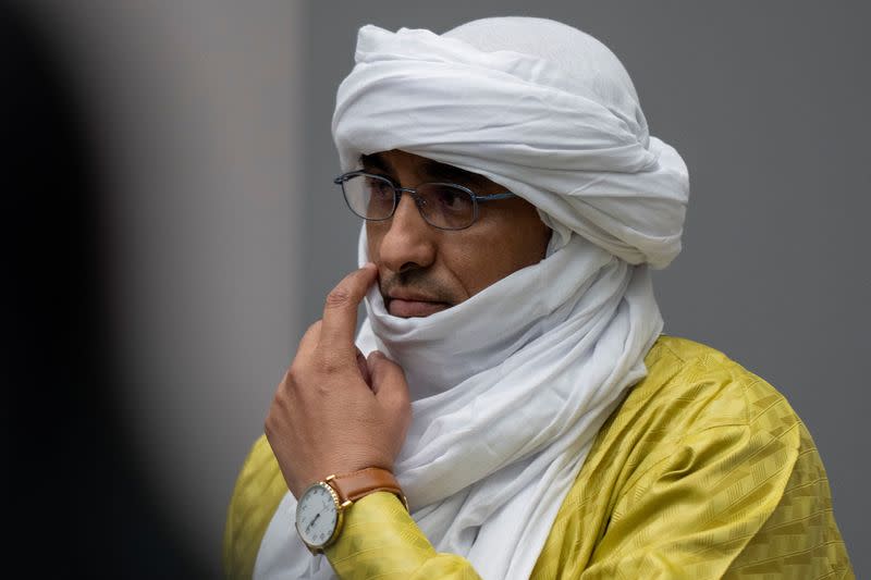 Al Hassan Ag Abdoul Aziz Ag Mohamed Ag Mahmoud rises as judges enter the courtroom of the International Criminal Court in The Hague