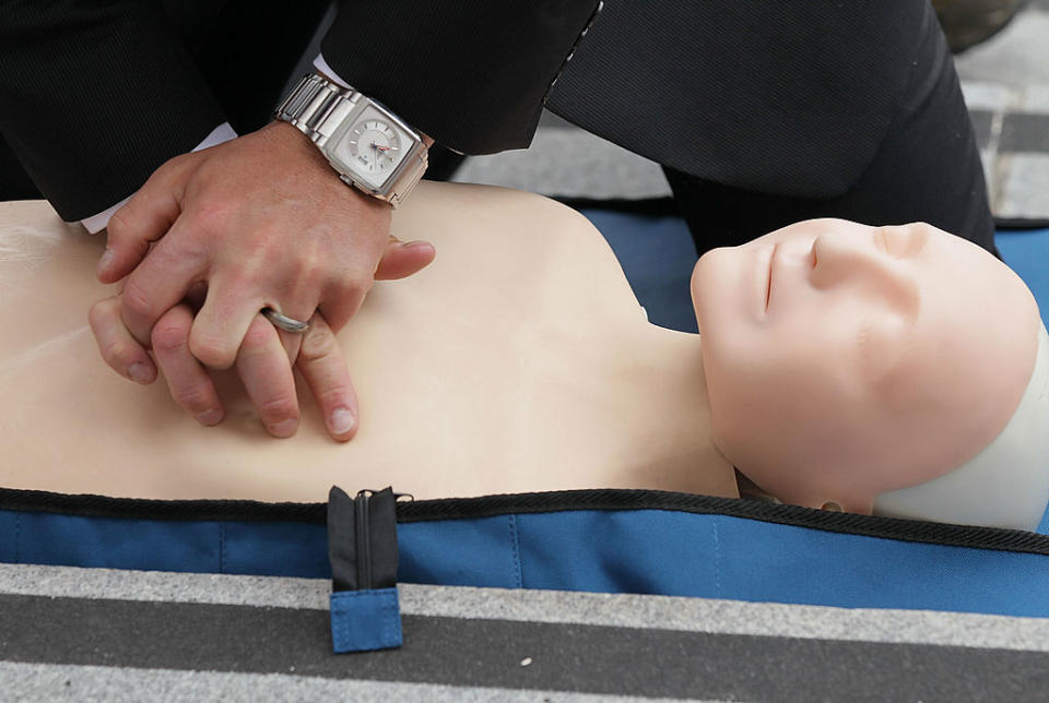 A person practices CPR on a mannequin