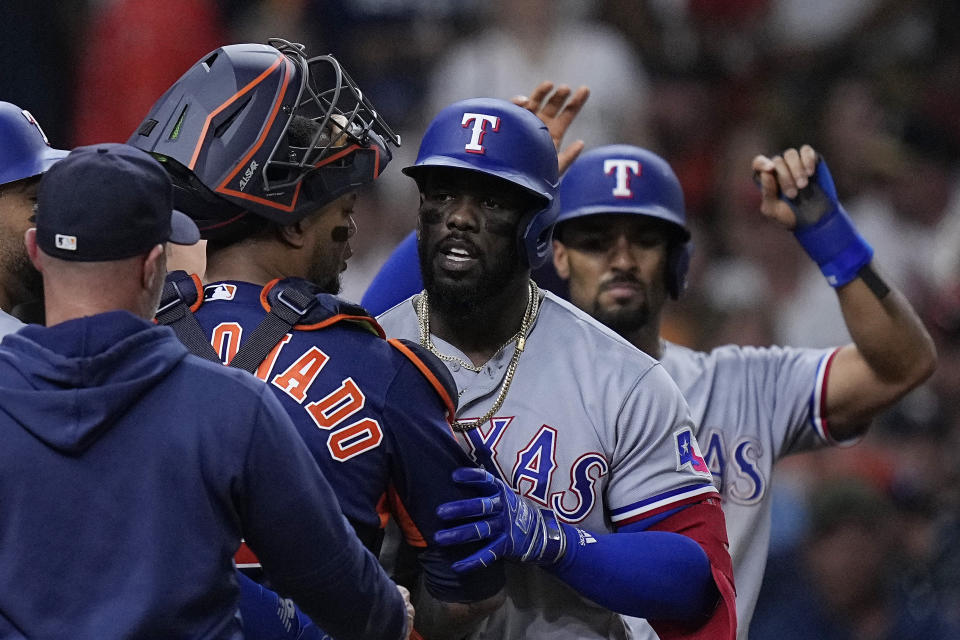 FILE - Houston Astros catcher Martin Maldonado and Texas Rangers' Adolis Garcia, second from right, argue as the benches clear following Garcia's grand slam during the fifth inning of a baseball game July 26, 2023, in Houston. Everything is certainly bigger deep in the heart of Texas this baseball postseason, with a Lone Star State matchup for a spot in the World Series. The Astros are in their seventh straight ALCS, this time against the Rangers for the first time. (AP Photo/Kevin M. Cox, File)