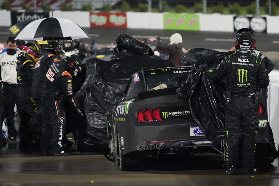 Pit crews cover cars during a rain delay in the NASCAR Xfinity Series auto race at Martinsville Speedway in Martinsville, Va., Friday, April 9, 2021. (AP Photo/Steve Helber)