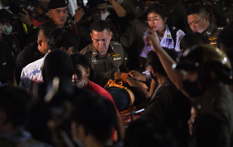 Panupong "Mike Rayong" Jadnok is carried on a stretcher by police at Prachachuen police station in Bangkok