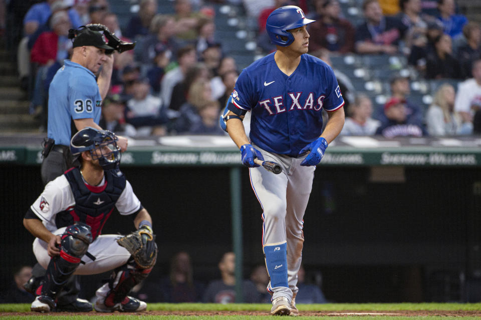 Texas Rangers' Nathaniel Lowe watches his two-run home run next to Cleveland Guardians' Luke Maile off Kirk McCarty during the fourth inning of the second game of a baseball doubleheader in Cleveland, Tuesday, June 7, 2022. Umpire Ryan Blakney watches from behind. (AP Photo/Phil Long)