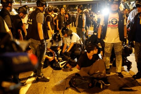 Police officers detain protesters during a protest to demand authorities scrap a proposed extradition bill with China, on Gloucester Road in Hong Kong