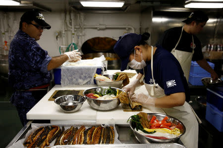 A female cook (R) prepares sushi rolls for the ship's meal in the galley on Japanese helicopter carrier Kaga in the Indian Ocean, September 26, 2018. REUTERS/Kim Kyung-Hoon