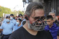 A man wears a muzzle during a protest in Bucharest, Romania, Saturday, Sept. 19, 2020. Several hundred Romanians, including many families with young children, held a protest in the country's capital against measures meant to curb the spread of the coronavirus, especially social distancing and the mandatory use of masks in schools. (AP Photo/Vadim Ghirda)