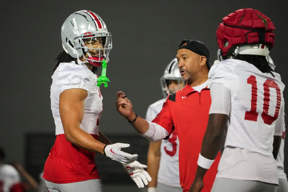 Ohio State secondary coach Tim Walton works with cornerbacks Jordan Hancock and Denzel Burke (10) during spring practice.