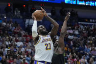 Los Angeles Lakers forward LeBron James (23) shoots against New Orleans Pelicans forward Zion Williamson in the first half of an NBA basketball game in New Orleans, Sunday, April 14, 2024. (AP Photo/Gerald Herbert)