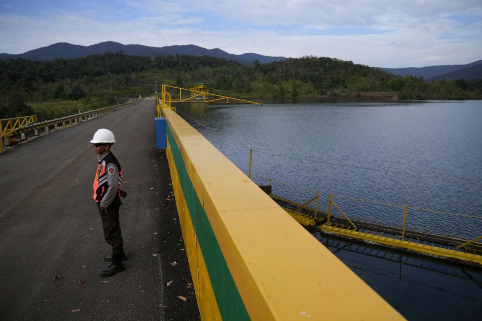 A security guard stands at Larona hydroelectric plant, one of three dams that powers PT Vale Indonesia's processing plant, in Sorowako, Indonesia, Wednesday, Sept. 13, 2023. Vale churns out 75,000 tons of nickel a year for use in batteries, electric vehicles, appliances and many other products. (AP Photo/Dita Alangkara)