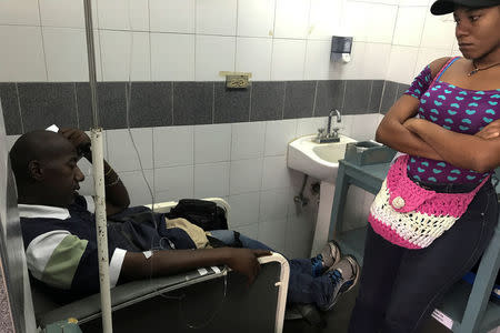 Pablo Tejada, a kidney transplanted patient, receives treatment in front of his daughter at a state hospital in Caracas, Venezuela February 7, 2018. REUTERS/Carlos Garcia Rawlins