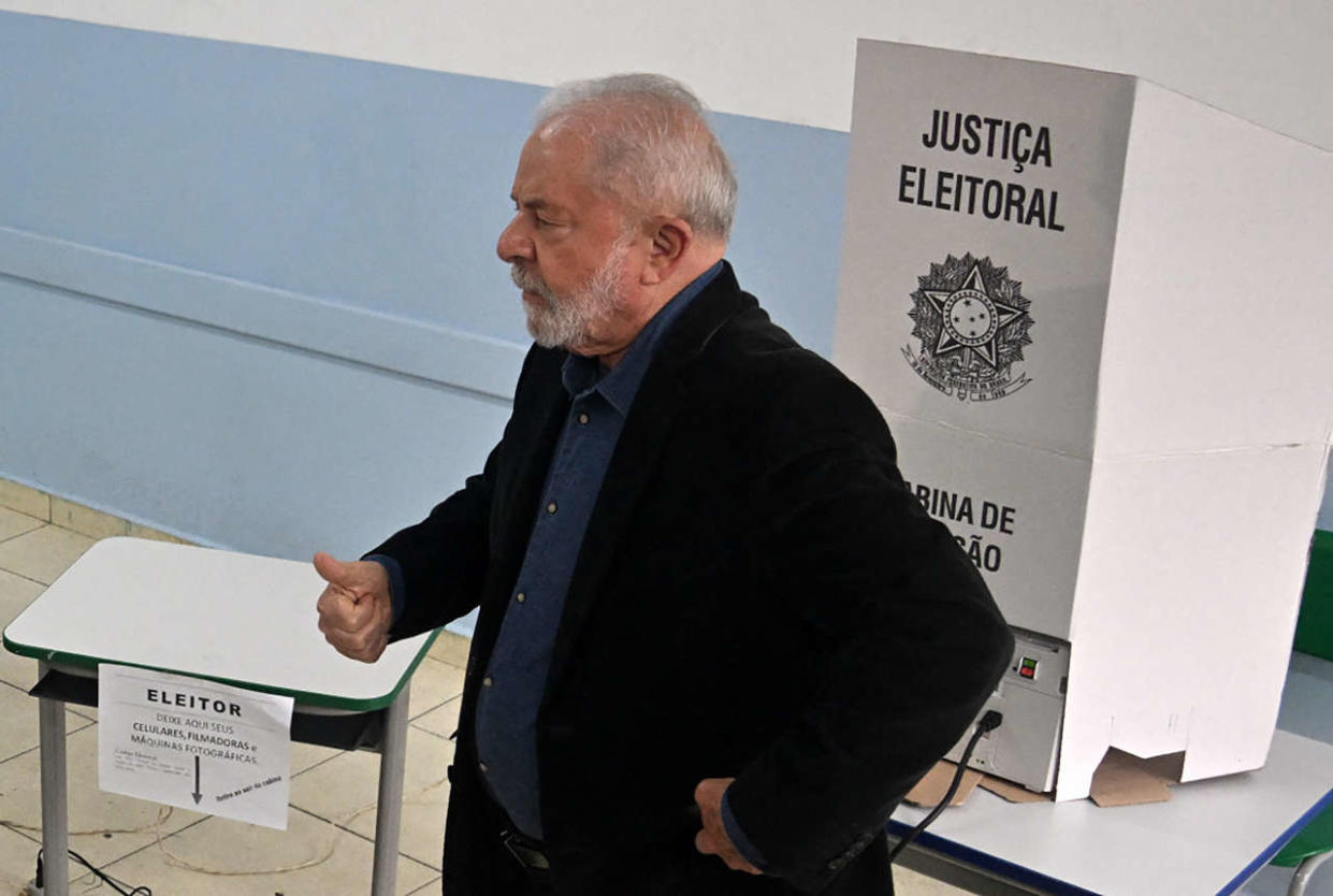 Brazilian former president (2003-2010) and candidate for the leftist Workers Party (PT) Luiz Inacio Lula da Silva (C), gives a thumb up as he votes during the legislative and presidential election, in Sao Paulo, Brazil, on October 2, 2022. - Voting began early Sunday in South America's biggest economy, plagued by gaping inequalities and violence, where voters are expected to choose between far-right incumbent Jair Bolsonaro and leftist front-runner Luiz Inacio Lula da Silva, any of which must garner 50 percent of valid votes, plus one, to win in the first round. (Photo by Nelson ALMEIDA / AFP)