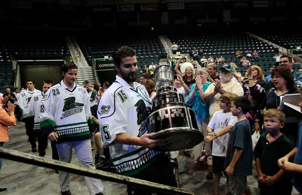 Florida Everblades team captain Mathieu Roy, center, carries the Kelly Cup up to stage during the Kelly Cup Championship fan celebration at Germain Arena in Estero. Everblades fans had the opportunity to talk to players, get autographs and have their photos taken with the Kelly Cup.