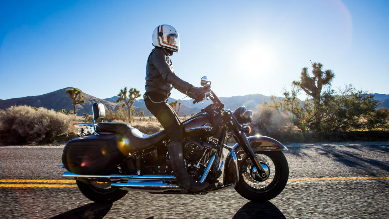 Motorcycle driver standing on his Harley Davidson