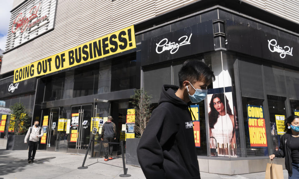 FILE - In this Wednesday, Sept. 30, 2020, file photo, a man wearing a mask amid the coronavirus pandemic walks by a Century 21 department store, in the Brooklyn borough of New York. The discount department store chain has filed for Chapter 11 bankruptcy protection and is closing its 13 stores. Responses to the coronavirus pandemic and police brutality dominated legislative sessions in 2020 and led to many new laws that will take effect in the new year. (AP Photo/Mark Lennihan, File)