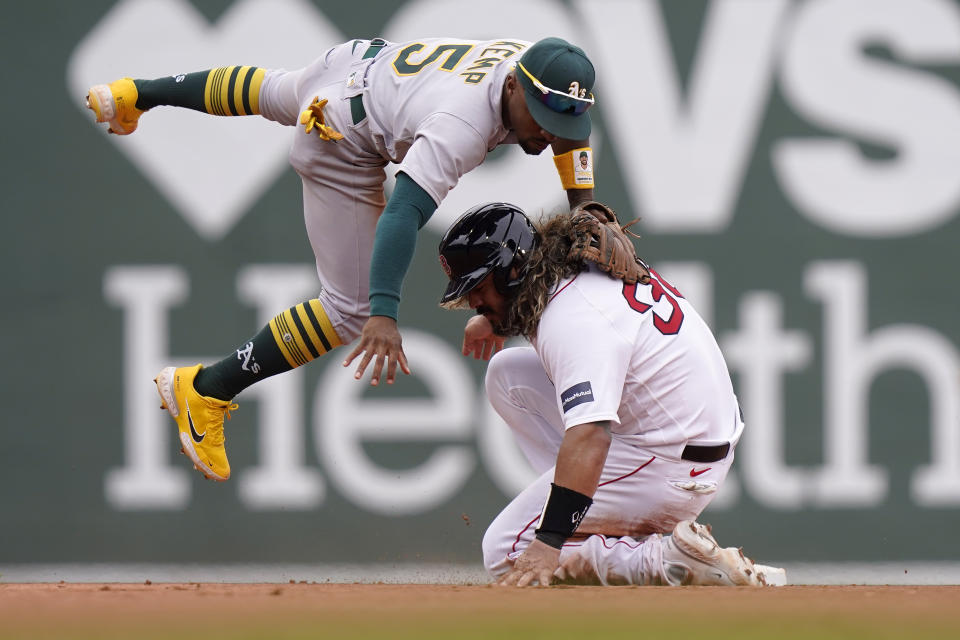Boston Red Sox's Jorge Alfaro, bottom, slides out at second base as Oakland Athletics' Tony Kemp, top, follows through on a throw to first to complete a double play in the fourth inning of a baseball game, Sunday, July 9, 2023, in Boston. (AP Photo/Steven Senne)