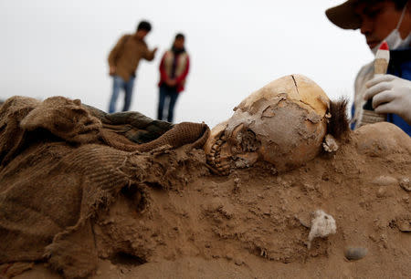 Archaeologist works at a tomb of one of sixteen Chinese migrants, discovered buried at the turn of the 20th century in the pre-colombian pyramid of Bellavista, according to Ministry of Culture, in Lima, Peru, August 24, 2017. REUTERS/Mariana Bazo