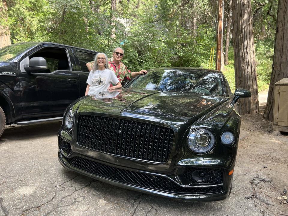 bob and suzanne williams stand by a green bentley flying spur speed