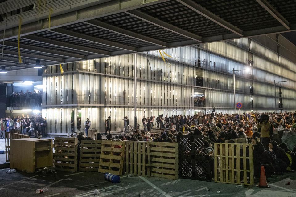 Protesters use makeshift barricades during a demonstration at El Prat airport, outskirts of Barcelona, Spain, Monday, Oct. 14, 2019. Spain's Supreme Court on Monday sentenced 12 prominent former Catalan politicians and activists to lengthly prison terms for their roles in a 2017 bid to gain Catalonia's independence, sparking protests across the wealthy Spanish region. (AP Photo/Bernat Armangue)