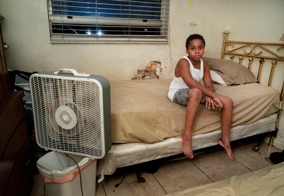 Jimmon Sharpe, 9, sits on his bed in the room he shares with his two sisters. He lives with his grandparents Catherine and Otis Hall in Boynton Beach. Their mother is in the hospital after a series of heart attacks. Their father is recovering from a stroke. The home has no AC and no screens on the windows.