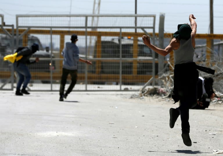 Palestinian protesters hurl stones towards Israeli security forces during clashes following a demonstration in solidarity with hunger-striking Palestinian prisoners, in front of Ofer prison in the West Bank, on April 20, 2017