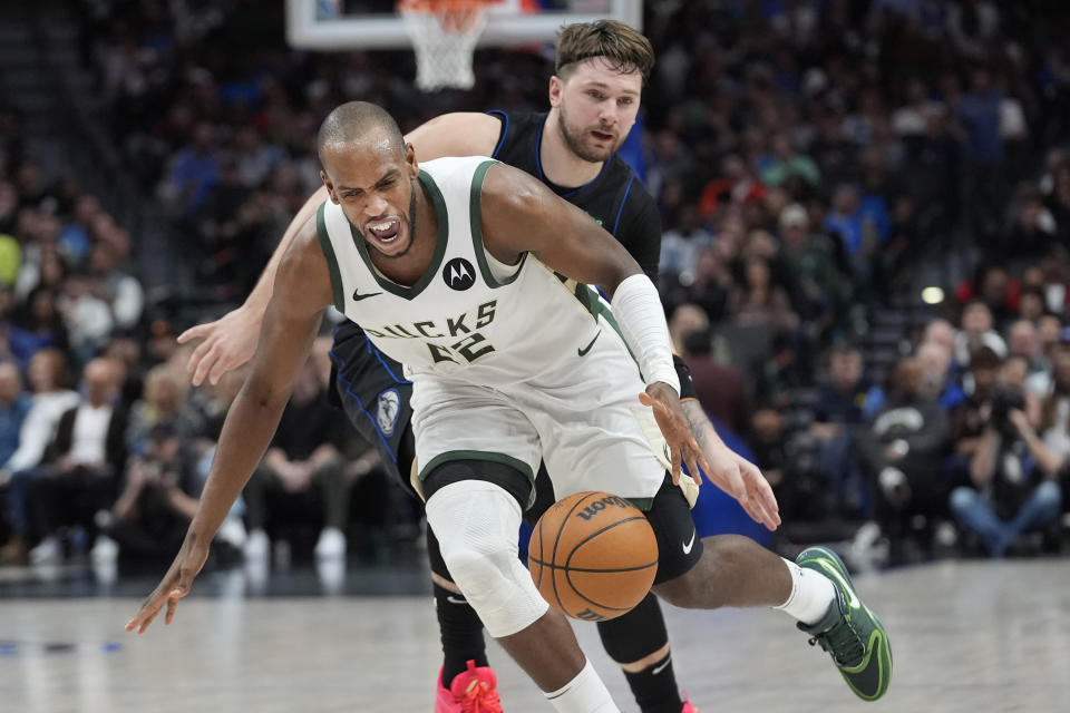 Milwaukee Bucks forward Khris Middleton (22) dribbles past Dallas Mavericks guard Luka Doncic (77) during the first half of an NBA basketball game in Dallas, Saturday, Feb. 3, 2024. (AP Photo/LM Otero)