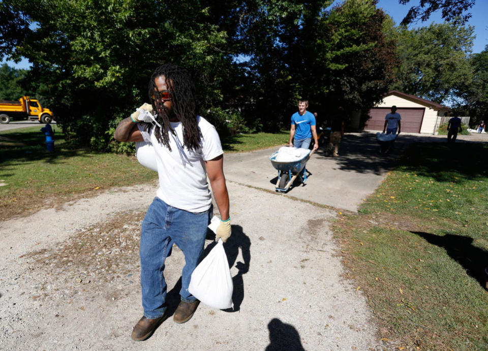 <p>Trey Washington, a student in Hawkeye Community College sustainable construction and design program, carries sandbags from the backyard of a home on Belle Street after the Cedar River receded from homes in the area Monday, Sept. 26, 2016, in Cedar Falls, Iowa. (Matthew Putney/The Waterloo Courier via AP)</p>