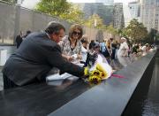 New Jersey governor Chris Christie puts a flower by the name of Walter Philip Travers at the 9/11 Memorial during ceremony marking the 12th Anniversary of the attacks on the World Trade Center in New York September 11, 2013. REUTERS/Ozier Muhammad/Pool
