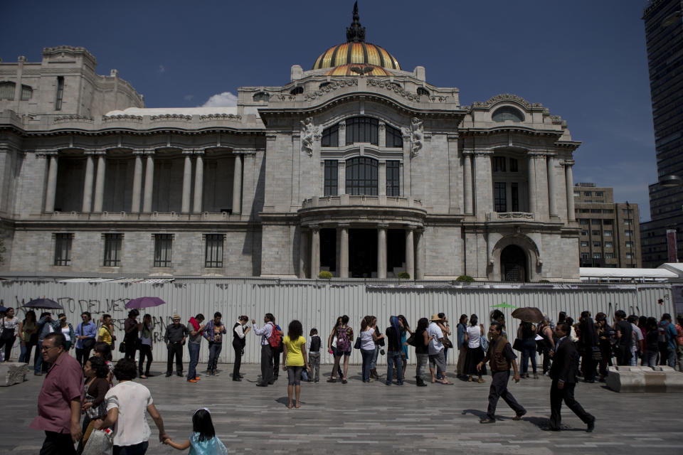 Well-wishers wait in line outside the Palace of Fine Arts to pay their respects to beloved author Gabriel Garcia Marquez, in Mexico City, Monday, April 21, 2014. The ashes of Garcia Marquez were taken Monday to Mexico City's majestic Palace of Fine Arts, where thousands of admirers began paying tribute to the Colombian Nobel laureate considered one of the greatest Spanish-language authors of all time. (AP Photo/Rebecca Blackwell)