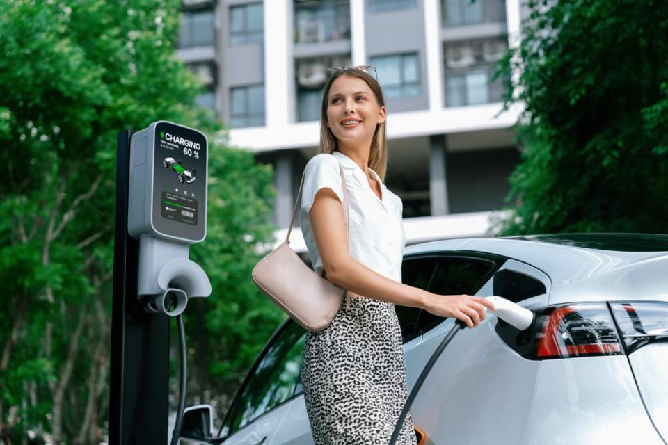 A person charging an electric vehicle or EV.