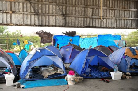 Asylum seekers pass the time in a makeshift tent camp near the Brownsville-Matamoros International Bridge where they wait in hopes of soon being granted entry into the U.S. in Matamoros